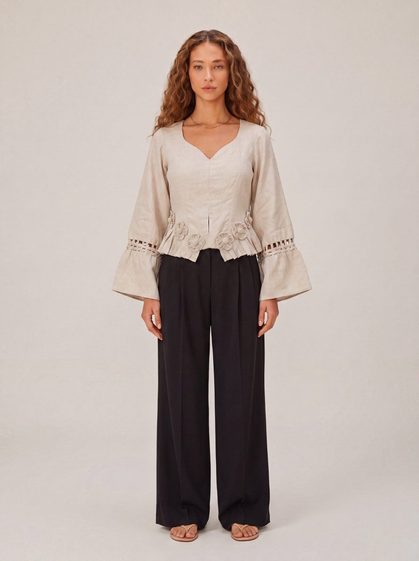 Rumi Top, handcrafted pure linen corset top with hand-braided sleeves, pleated ruffle hem and recycled floral appliques – back view