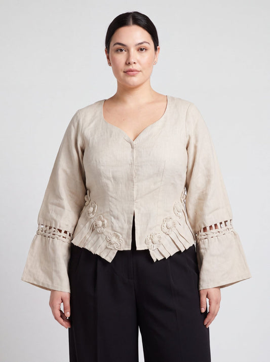 Rumi Top, handcrafted pure linen corset top with hand-braided sleeves, pleated ruffle hem and recycled floral appliques – close-up detail